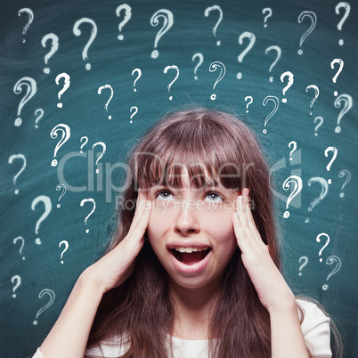 Young girl with questioning expression and question marks