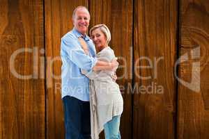 Composite image of happy mature couple hugging and smiling