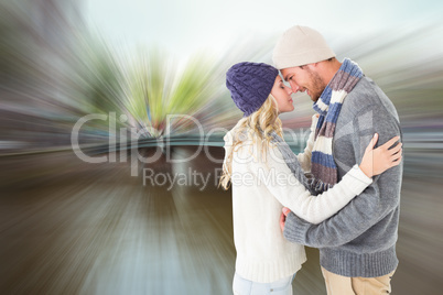 Composite image of attractive couple in winter fashion hugging