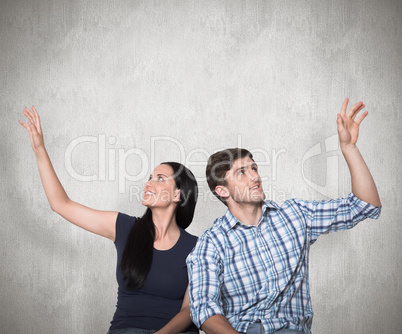 Composite image of young couple sitting on floor smiling