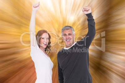 Composite image of casual couple cheering at camera