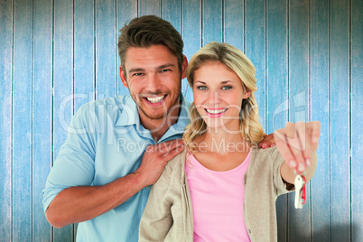 Composite image of attractive young couple showing new house key