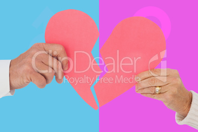 Composite image of couple holding a broken paper heart
