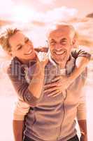 Happy hugging couple on the beach looking at camera