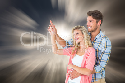 Composite image of attractive young couple embracing and pointin