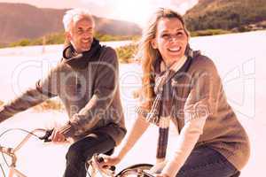 Carefree couple going on a bike ride on the beach