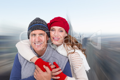 Composite image of happy couple in warm clothing