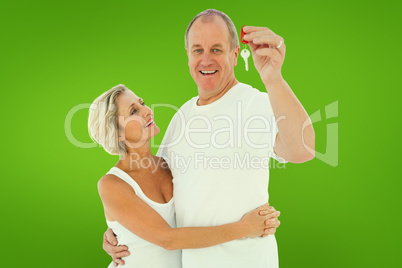 Composite image of mature couple smiling at camera with new hous