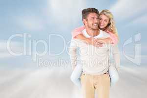 Composite image of handsome man giving piggy back to his girlfri