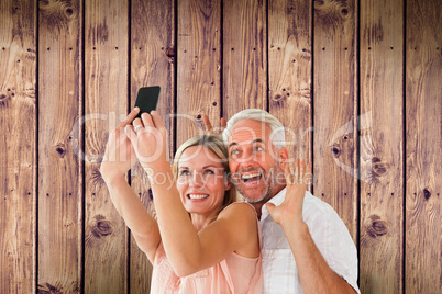 Composite image of happy couple posing for a selfie