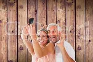 Composite image of happy couple posing for a selfie