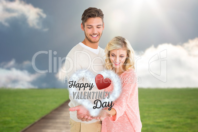 Composite image of attractive couple holding their hands out