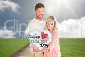 Composite image of attractive couple holding their hands out