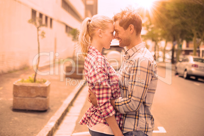 Couple in check shirts and denim hugging each other