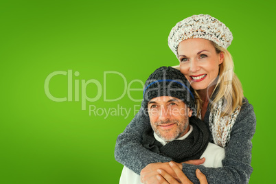 Composite image of happy couple in winter fashion embracing