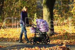 woman with baby in perambulator in the park