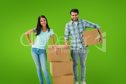 Composite image of attractive young couple with moving boxes
