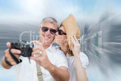 Composite image of vacationing couple taking photo