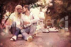 Cute young couple sitting on skateboard kissing