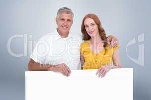 Composite image of casual couple showing a poster