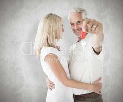 Composite image of happy couple showing their new house key