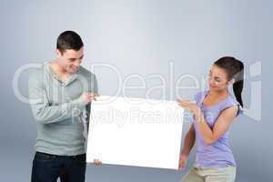 Composite image of young couple presenting banner together