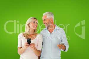 Composite image of happy couple texting on their smartphones