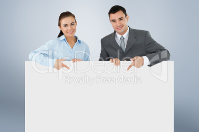 Composite image of business partners pointing at sign they are h