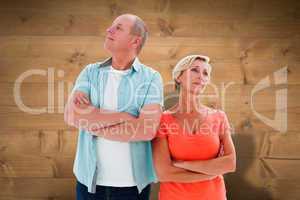 Composite image of thinking older couple with arms crossed
