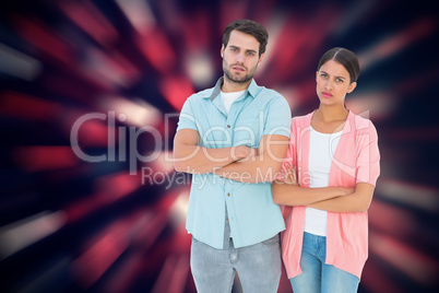 Composite image of serious couple with arms crossed