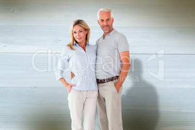 Composite image of happy couple standing and smiling at camera