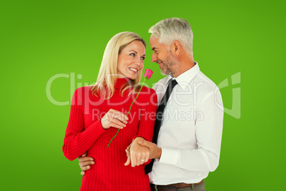 Composite image of handsome man giving his wife a pink rose