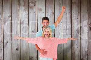 Composite image of attractive couple smiling and cheering