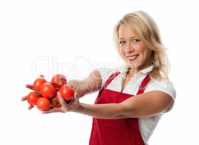 Frau mit Schürze zeigt eine Handvoll Tomaten