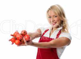 Frau mit Schürze zeigt eine Handvoll Tomaten
