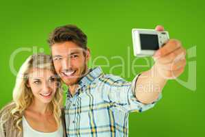 Composite image of attractive couple taking a selfie together