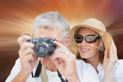 Composite image of vacationing couple taking photo