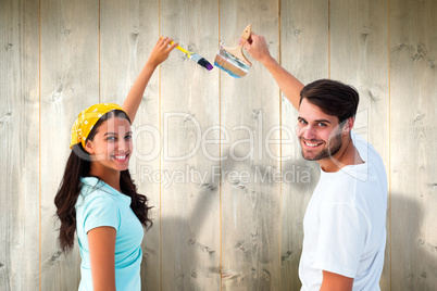 Composite image of happy young couple painting together