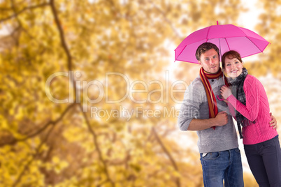 Composite image of couple standing underneath an umbrella