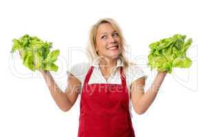 Frau mit Schürze präsentiert verschiedene Salate