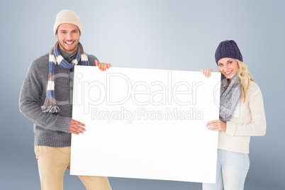 Composite image of attractive couple in winter fashion showing p