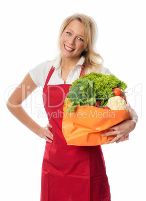 Frau mit Schürze hält Tasche mit Gemüse