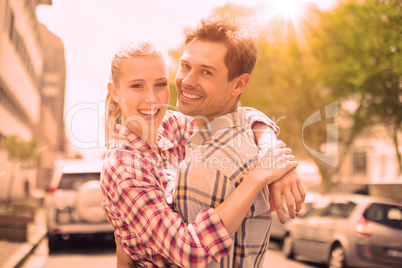 Couple in check shirts and denim hugging each other