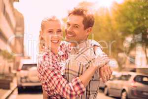 Couple in check shirts and denim hugging each other