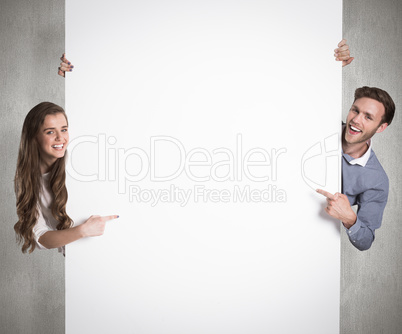 Composite image of happy young couple with blank board