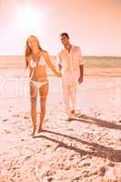 Smiling blonde walking away from man holding her hand