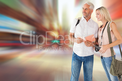 Composite image of happy tourist couple using the guidebook