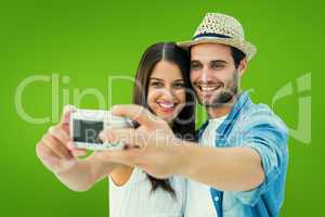 Composite image of happy hipster couple taking a selfie