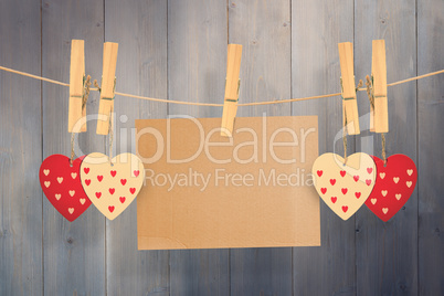 Composite image of hearts hanging on line with card