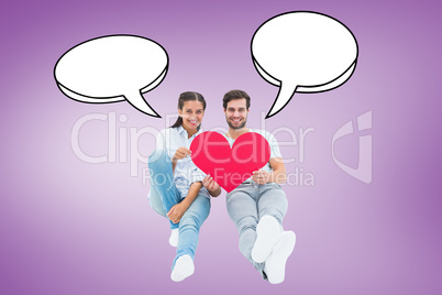 Composite image of cute couple sitting holding red heart